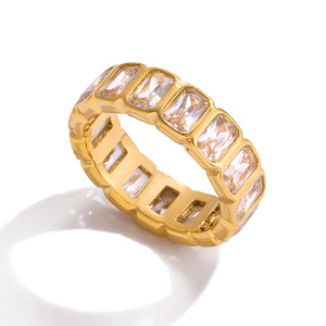 Gold-tone eternity ring with rectangular zircon stones in bezel settings around the band.