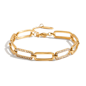Gold-tone paperclip bracelet with two zircon-accented links, a lobster clasp, and an extender chain
