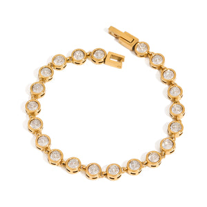 Gold-tone tennis bracelet with linked round bezel-set zircon stones and an open clasp.