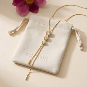 Cubic Zirconia Adjustable Lariat Necklace on the original simple pouch with a pink Japanese anemone