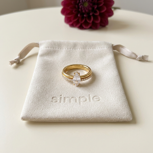 Double-Band Marquise Zircon Ring on the original simple pouch with a burgundy dahlia