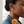 Oval gold stud earring lifestyle close-up with a teal blouse and apricot dahlia