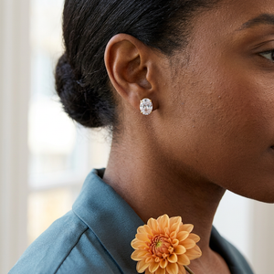 Oval gold stud earring lifestyle close-up with a teal blouse and apricot dahlia