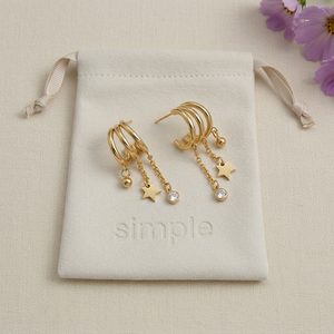 Revised CZ Tassel & Charm Earrings resting naturally on the pouch
