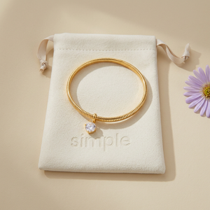 Round Zircon Charm Snake Bangle on the original simple pouch with a lavender aster