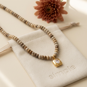 Sahara Jasper necklace on the cream simple pouch with a blurred autumn flower