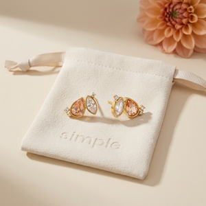 Topaz & Crystal-Tone Zircon Stud Earrings on the cream simple pouch with a peach dahlia